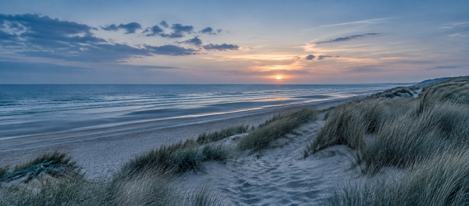 Strand en duinen bij de kust van Wassenaar bij zonsondergang